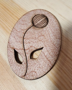 Photo of a wooden laser cut oval with a flower cut out of it