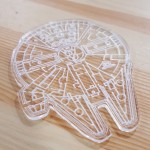 A photo of a millennium falcon laser cut out of clear acrylic.